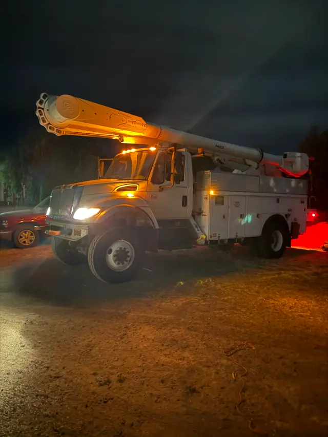 A West Valley aerial-lift truck at night with its work lights on
